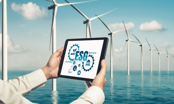 Green business transformation for environment saving and ESG business concept. Businessman using tablet to set corporate goal toward environmental friendly management and alternative clean energy use.