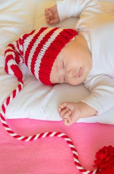 Baby sleeps in a Santa hat. Selective focus. People. Merry Christmas and Happy New Year, Holidays greeting card background. Selective focus.