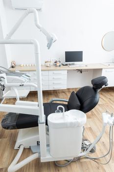 Modern dental cabinet in white colors. Defferent dental equipment, chair, lamp, drill machines. Concept dental treatment with microscope