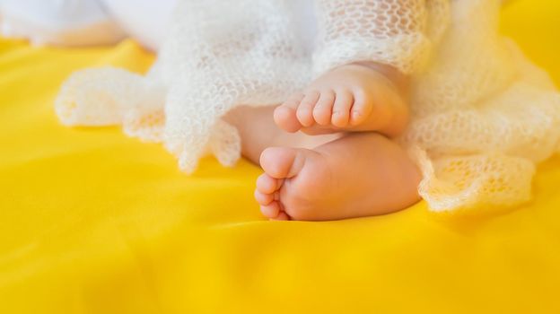 Baby feet on a yellow background. Selective focus. People. Merry Christmas and Happy New Year, Holidays greeting card background. Selective focus.