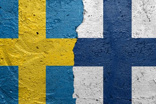 Sweden and Finland - Cracked concrete wall painted with a Swedish flag on the left and a Finnish flag on the right