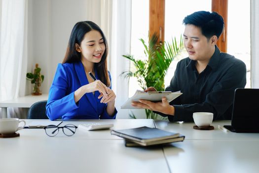 negotiation, analysis, discussion,asian male economist pointing out a document explaining the investment finance program to the company owner to plan marketing and hedging business risks