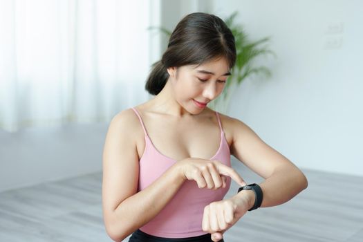 Health care, heart rate monitor, portrait of Asian beautiful woman using smart watch to select health programs such as yoga, cardio exercises, breathing meditation. to prepare before the activity