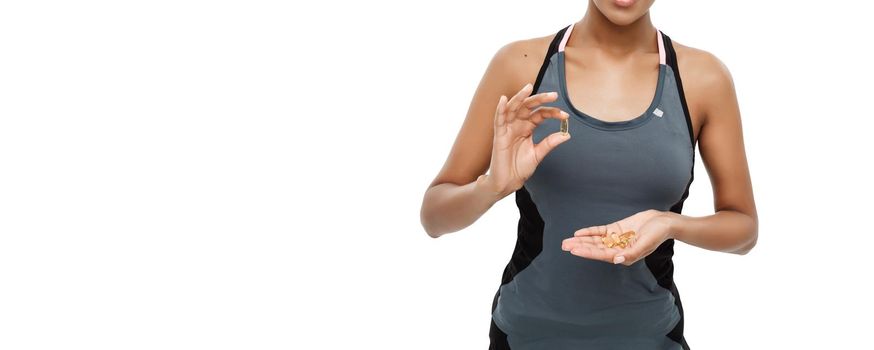 healthcare concept - Closeup portrait of beautiful African American taking a pill of Cod liver oil. Isolated on white studio background.