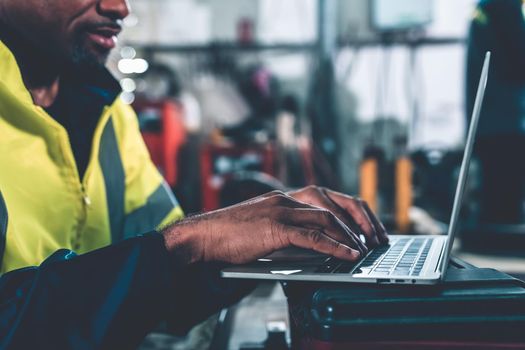 Factory worker working with laptop computer to do adept procedure checklist . Factory production line operator occupation quality control concept .