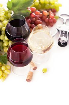 glasses of red and white wine and ripe grapes on table