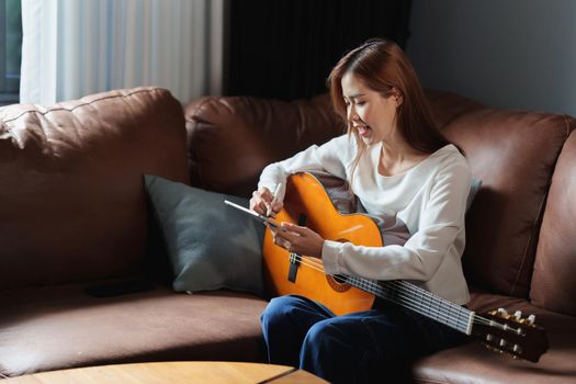 Young composer woman composing song writing on digital tablet