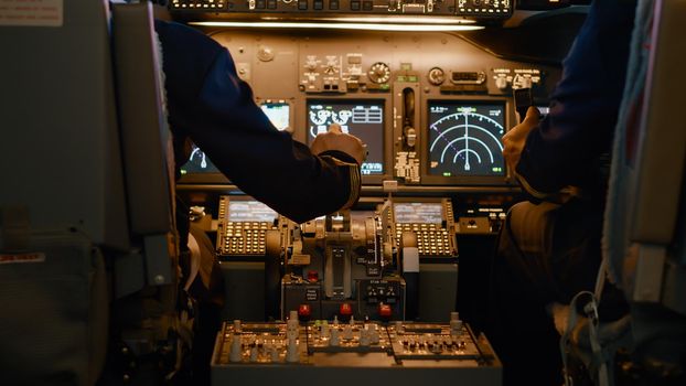 Airplane captain throttling engine to takeoff and fly plane, using power handle and control panel command. Pushing lever to travel and use aerial navigation, flying aircraft. Close up.