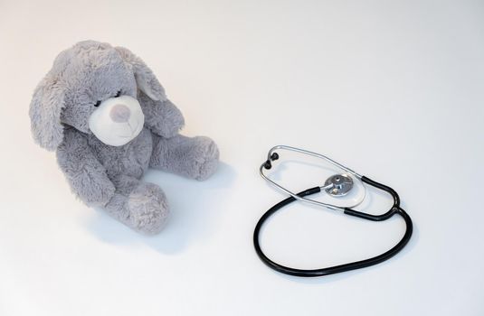 Teddy bear, isolated on white background, with a stethoscope. Health care concept. Copy space