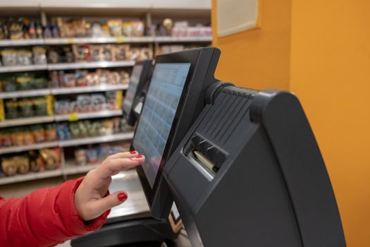 woman using self-service device in a store. market self help