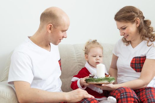 Baby child with hearing aid and cochlear implant having fun with parents in christmas room. Deaf and health