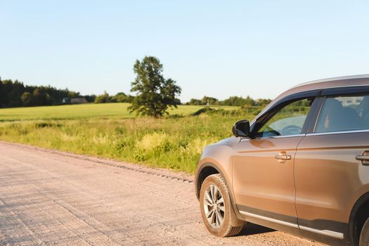 Car parked in countryside on rural landscape and blue sky at sunset copy space background. Summer, transportation, traveling concept.