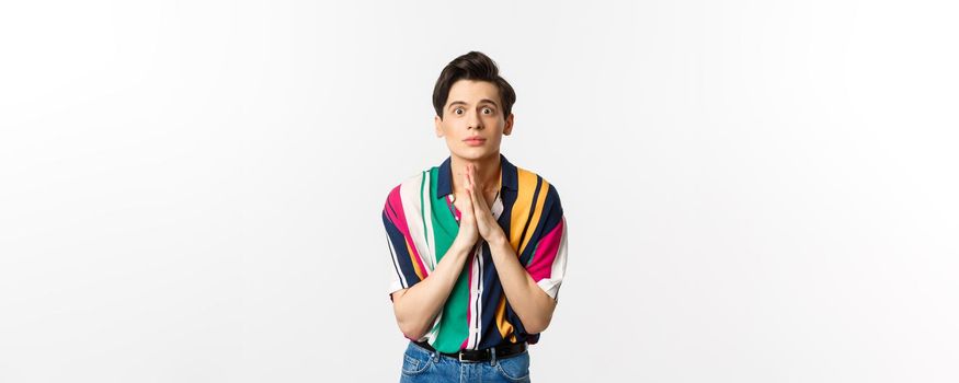 Image of hopeful young man begging for help, staring at camera and pleading for favour, asking advice, standing over white background.