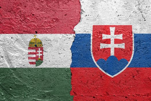 Hungary and Slovakia - Cracked concrete wall painted with a Hungarian flag on the left and a Slovakian flag on the right