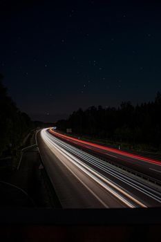 long exposure of highway during the night with stars visible in the sky