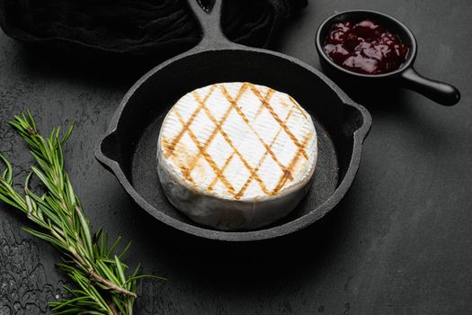 Baked Camembert cheese, on black dark stone table background