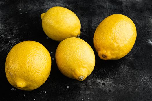 Fresh ripe lemons set, on black dark stone table background
