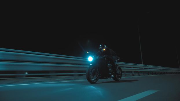 A man rides a sports motorcycle on a night track in 4k