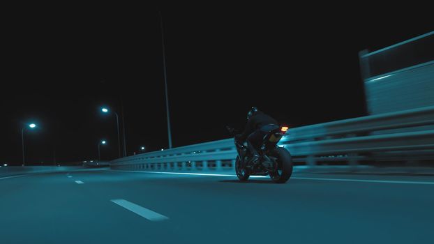 A man rides a sports motorcycle on a night track in 4k