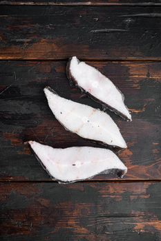 Frozen fish cut set, on old dark wooden table background, top view flat lay