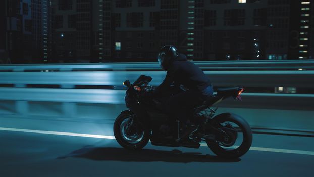 A man rides a sports motorcycle through the city at night in 4k