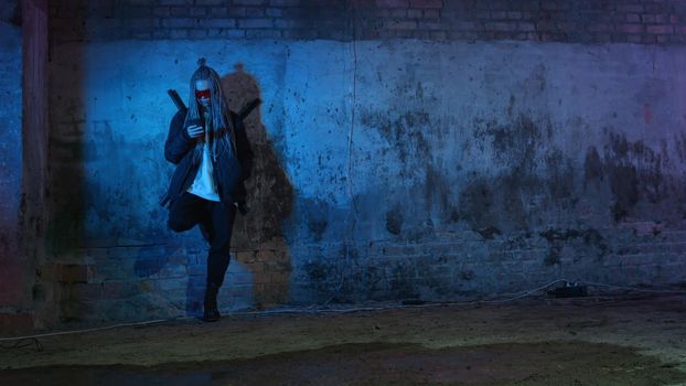 a girl with dreadlocks and katanas in red glasses is texting on a mobile phone against a neon brick wall 4k