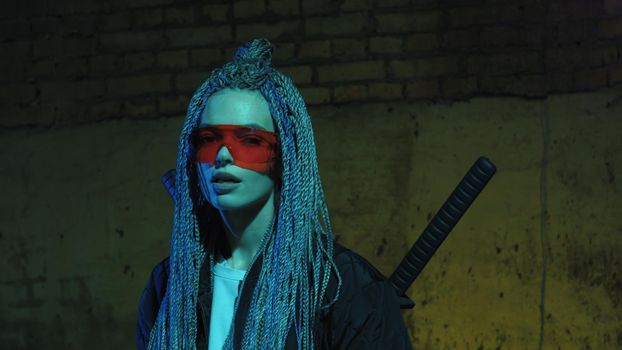 girl with dreadlocks and katanas in red glasses posing against a neon brick wall 4k