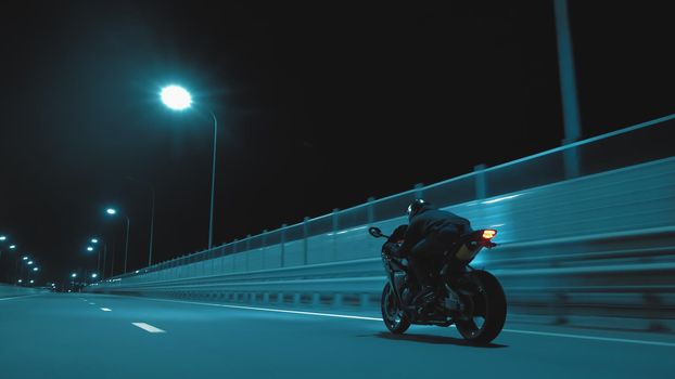 A man rides a sports motorcycle on a night track in 4k