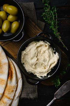 Healthy Homemade Creamy Hummus, on old dark wooden table background, top view flat lay