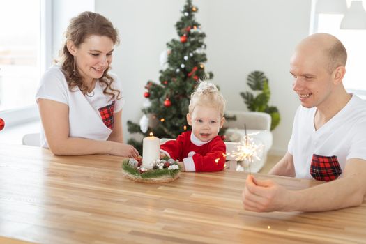 Baby child with hearing aid and cochlear implant having fun with parents in christmas room. Deaf and health