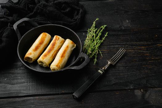 Georgian crepes stuffed, on black wooden table background, with copy space for text