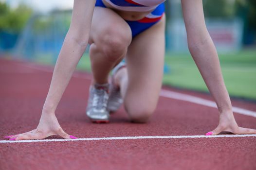 Close-up of female legs. The runner in the stadium is ready for the race