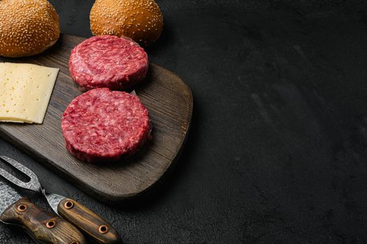 Burger patty, on black dark stone table background, with copy space for text