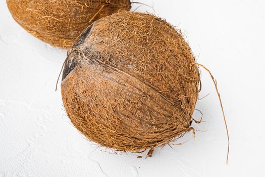 Whole ripe fresh Coconut set, on white stone table background