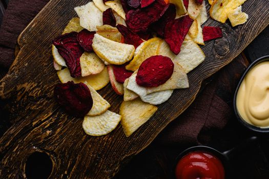 Root Vegetable Crisps set, on black wooden table background, top view flat lay