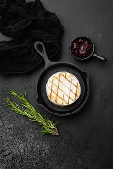 Baked Camembert cheese, on black dark stone table background, top view flat lay, with copy space for text