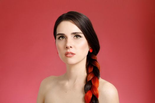 Portrait of a young beautiful well-groomed half-naked woman on a red background.