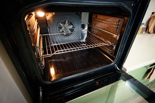 Open built-in oven with lighting in the home kitchen.