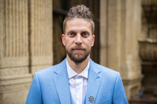 Man in blue three piece suit, outdoor portrait.