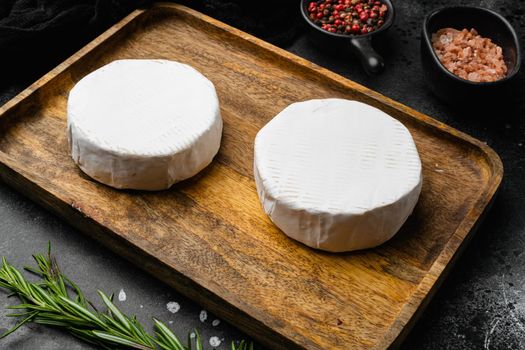 White cheese brie or camembert. Gourmet appetizer, on black dark stone table background