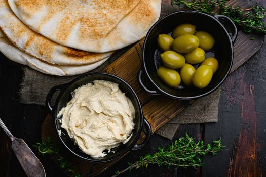 Hummus traditional Jewish creamy lunch, on old dark wooden table background, top view flat lay