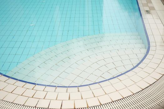 an empty swimming pool with poll stair.