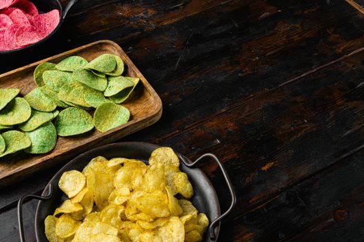 Crispy potato chips, on old dark wooden table background, with copy space for text