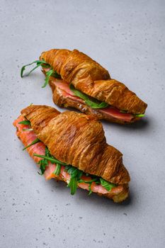 Croissant sandwich with salmon set, on gray stone table background