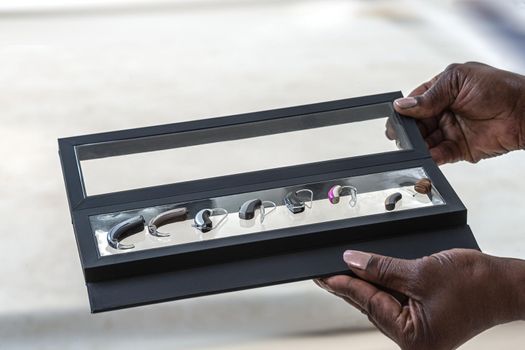 Panel of hearing aids of different dimensions in a presentation box