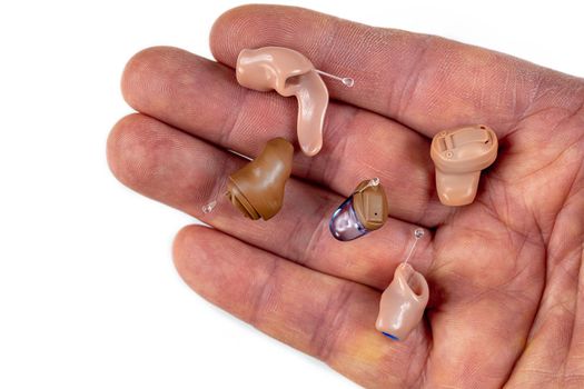 Panel of in-ear prostheses in the hand seen from above