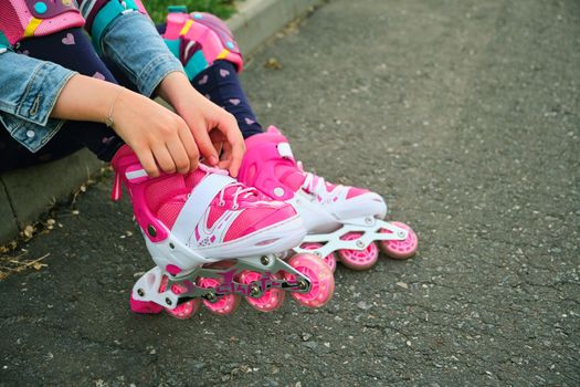 little girl learning to roller skate outdoor. Child enjoying roller skating ride outdoors. Close-up Of Legs Wearing Roller Skating Shoe, Outdoors