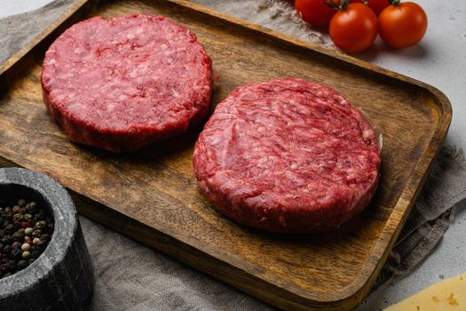 Fresh raw minced homemade farmers grill beef burgers, on gray stone table background