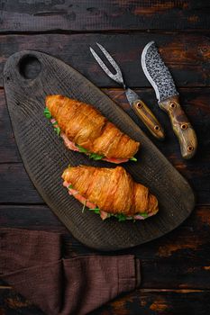 Croissant sandwich with salmon set, on old dark wooden table background, top view flat lay