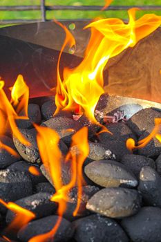 Preparing Barbeque BBQ Campfire and burning wood with orange flames im Speckenbütteler Park Lehe Bremerhaven Bremen Germany.